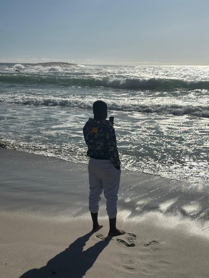 Kupela at the waterline on the beach at Camps Bay, Cape Town