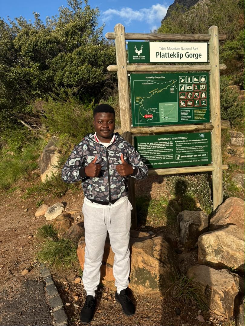 Kupela at the Platteklip Gorge trail sign, partway up Table Mountain