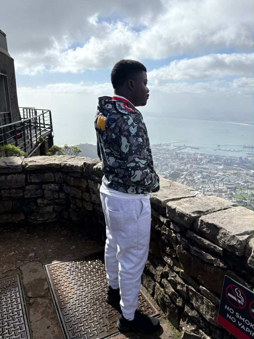 Kupela at the summit wall on Table Mountain, looking out over Cape Town and Table Bay
